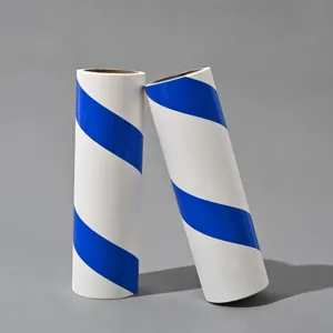 Lint roller refill detail showing dual white and blue striped adhesive paper rolls for home cleaning.