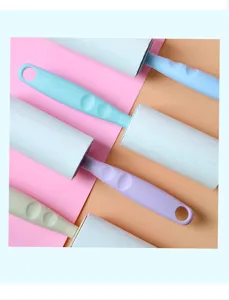 Close-up detail of colorful lint rollers with ergonomic handle for clothes cleaning.