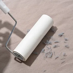 Lint roller with white sticky paper and metal handle for clothes and fabric hair dust removal.