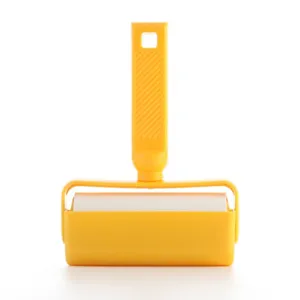 Yellow lint roller for clothes with dust cover and tearable sticky paper for pet hair cleaning.