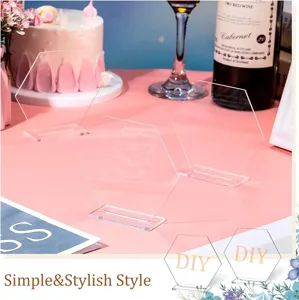 Detailed view of clear acrylic hexagon table place cards with bases for wedding party decor.