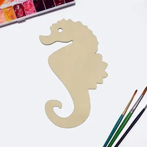 Gros plan sur la decoupe d'hippocampe en bois brut avec des pinceaux de peinture.