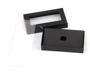 Black bow tie gift box detail showing textured paper, window cutout, and clear plastic sleeve.