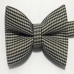 Classic black and white houndstooth bow tie detail, elegant gentleman fashion accessory.