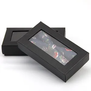 Black textured gift box with transparent window and floral bow tie inside for elegant men.
