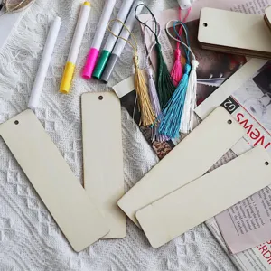 Close up of unfinished wooden blank bookmarks with colorful tassels and marker pens DIY craft.
