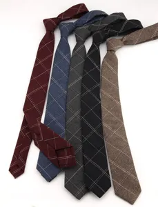 Vista detallada de la corbata estrecha de algodón a cuadros con textura fina y elegante.