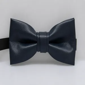 Detailopname van een donkerblauwe PU-lederen vlinderdas, met fijne textuur en strakke afwerking.