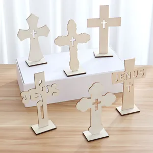 Detalle de cruz de madera con varios diseños recortados y letras jesus para decoracion mesa.