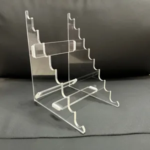 Clear acrylic multi-tier pen display stand detail showing stepped structure and holder slots.