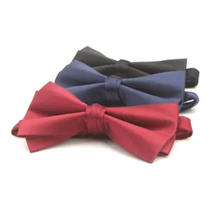 Close-up detail shot of classic solid color satin bow ties in red, blue, and black styles.