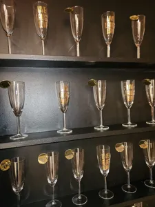 Close-up of acrylic drink tags on wine glass rims, perfect for wedding party decor details.
