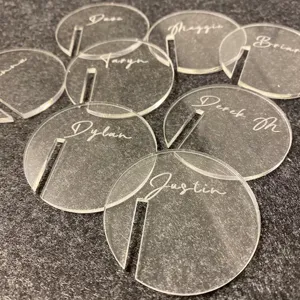 Close-up details of clear acrylic round drink tags with custom engraved names for glass edges.