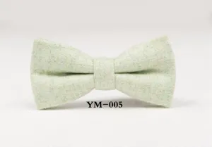 Green wool bow tie detail close-up, classic textured fabric design for men formal wear.