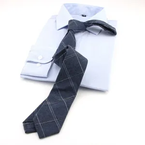 Elegante corbata fina de cuadros azul marino combinada con camisa formal clara.