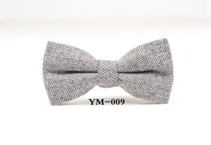 Grey herringbone wool bow tie detail showing fine fabric texture and neat tailoring shape.