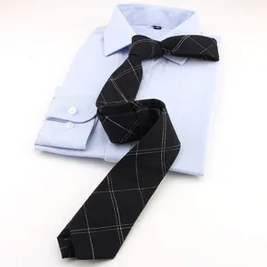 Vista detallada de una corbata negra a cuadros con camisa azul, estilo de negocios.