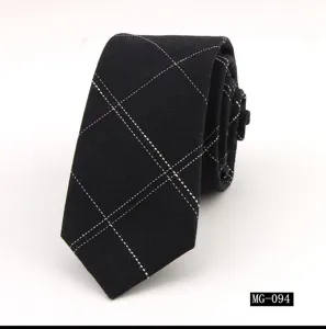 Vista detallada de una corbata delgada negra de algodón con patrón de cuadros blancos.
