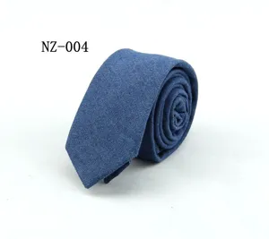 Vista detallada de la corbata de mezclilla azul con textura de tela y estilo limpio.