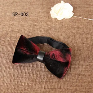 Detailed view of men's velvet bow tie with feather print and brooch, luxury wedding accessory.