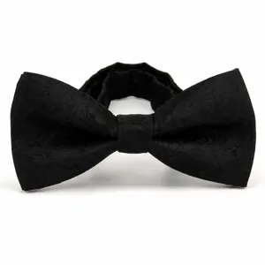 Detailed close-up of a black paisley bow tie, showing fine fabric texture and elegant weave.