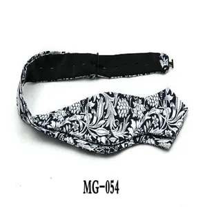 Detailed view of the black and white floral pattern and pointed shape on the cotton bow tie.