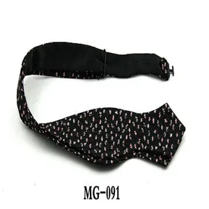 Black floral bowtie detail closeup, cute pink flower print pattern accessory for men.