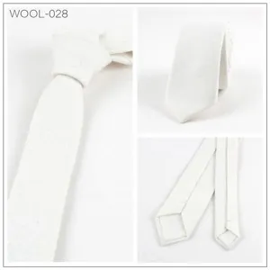 Detalles en primer plano de la corbata estrecha de lana blanca con textura cuidada.