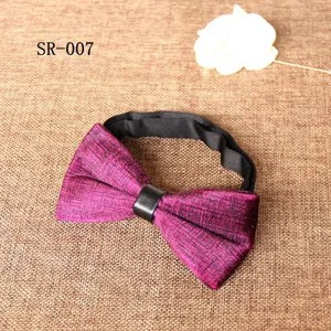 Close-up detail of magenta velvet bow tie with black leather center ring and adjustable neck strap.