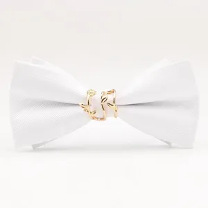 Gros plan détaillé d'un nœud papillon en tissu blanc avec un élégant anneau en métal doré.