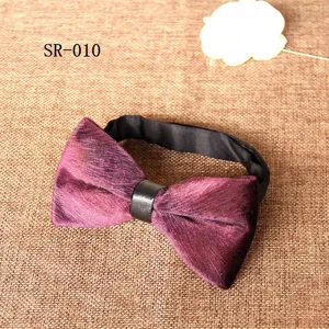 Detailed view of luxury purple velvet bow tie with black leather center knot and strap.