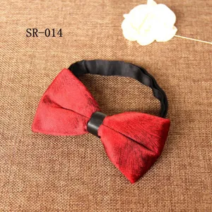 Close-up detail of a red velvet bow tie with black strap, showcasing premium texture and fabric.