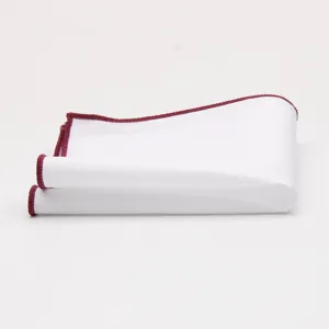Pocket square detail showing clean white cotton fabric and neat burgundy rolled edge trim.
