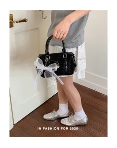 Chic black women handbag with elegant white bow detail, versatile commuter shoulder crossbody bag.