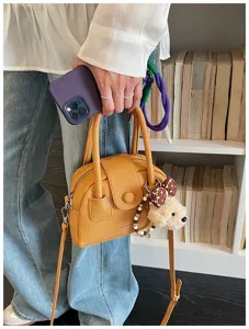 Detailed close-up view of yellow women bowling handbag featuring cute plush puppy keychain.