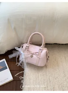 Pink sweet style handbag detail, featuring bow, lace trim and heart charm for chic look.