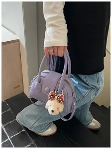 Detailed shot of lavender bowling bag with cute puppy plush charm and silver hardware.
