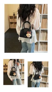 Women's stylish black bowling handbag with cute bear pendant, versatile crossbody bag.