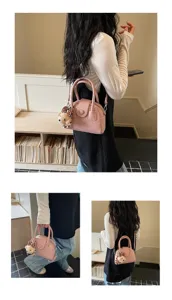 Pink bowling handbag for women with cute bear charm, versatile crossbody pillow bag style.
