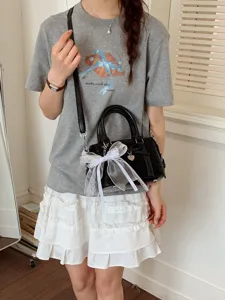 Chic black women handbag with elegant white bow knot, versatile commuter shoulder crossbody bag.