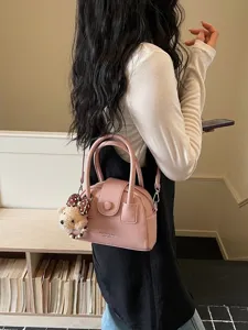 Chic pink bowling handbag for women, versatile crossbody shoulder bag with cute bear charm.