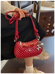 Red polka dot shoulder bag detail featuring sweet bow and cute balloon dog charm pendant.