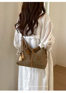 Zomerse strooien schoudertas voor dames, stijlvolle bucket bag met franjes en retro details.