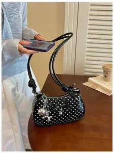 Black polka dot shoulder bag for women, stylish underarm purse with bow and cute dog charm.