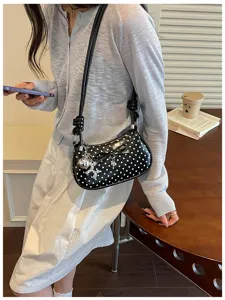 Chic black polka dot shoulder bag for women, trendy underarm crossbody bag with bow and charms.