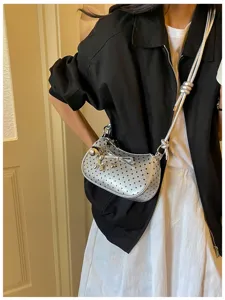 Close-up detail shot of the stylish silver polka dot shoulder bag with cute metallic charms.