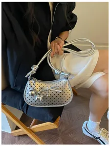 Silver metallic polka dot shoulder bag with cute bow and metal charm for women.