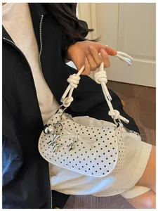 Stylish white polka dot underarm bag with cute bow and metal charm for women daily fashion.