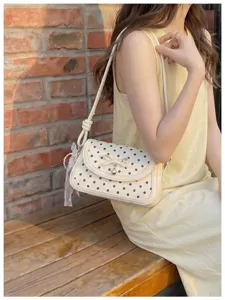 Chic polka dot shoulder bag for women, trendy underarm bag with cute bow and pendant.