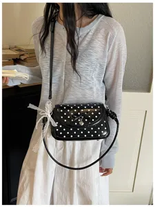 Stylish black and white polka dot crossbody shoulder bag with cute bow detail for women.